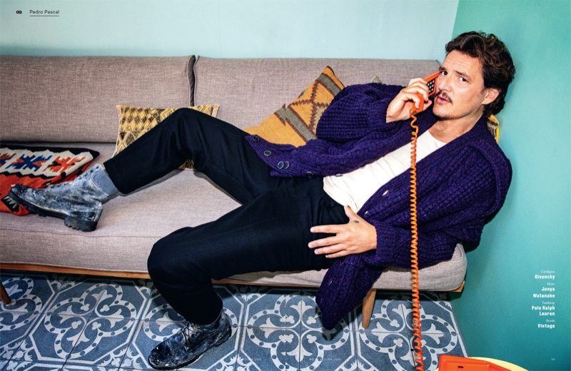 Taking a phone call, Pedro Pascal dons a cardigan sweater by Givenchy. Posing for GQ Germany, Pascal's look is complete with Junya Watanabe pants, a POLO Ralph Lauren tank, and vintage boots.