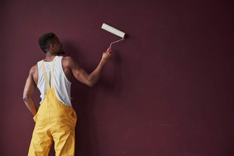 Black Man Painting Wall Purple Yellow Overalls