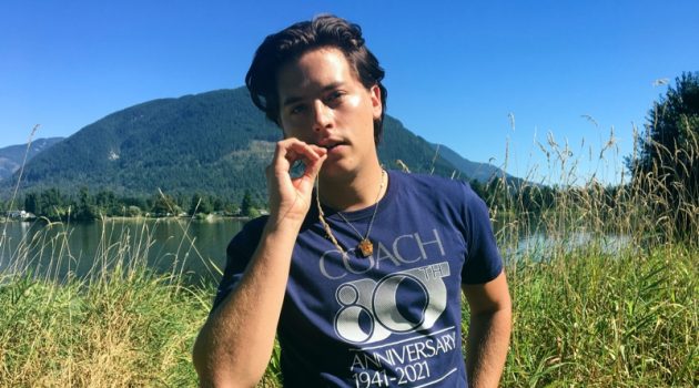 Cole Sprouse wears a t-shirt commemorating Coach's 80th anniversary.
