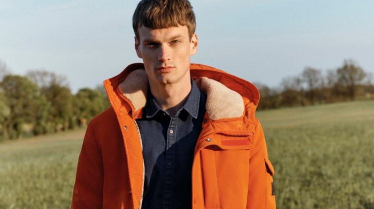 Max Bender rocks an orange hooded jacket for Esprit's fall-winter 2020 campaign.