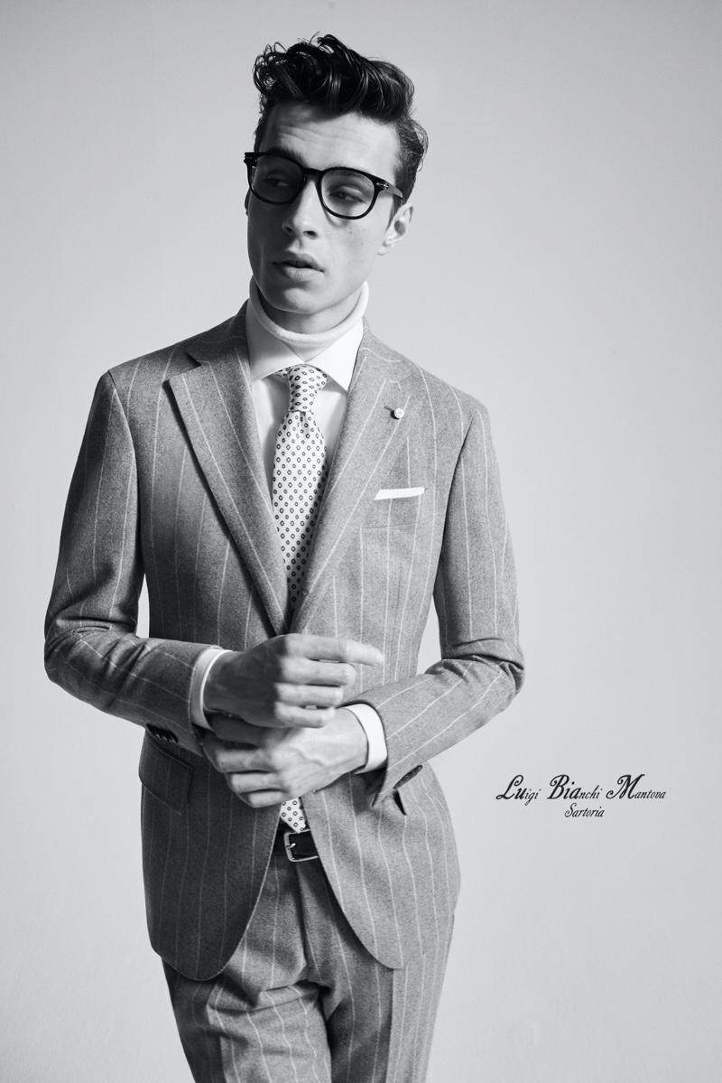 Charming in a pinstripe suit by Luigi Bianchi Mantova, Adrien Sahores finishes his look with a smart pair of black framed glasses.