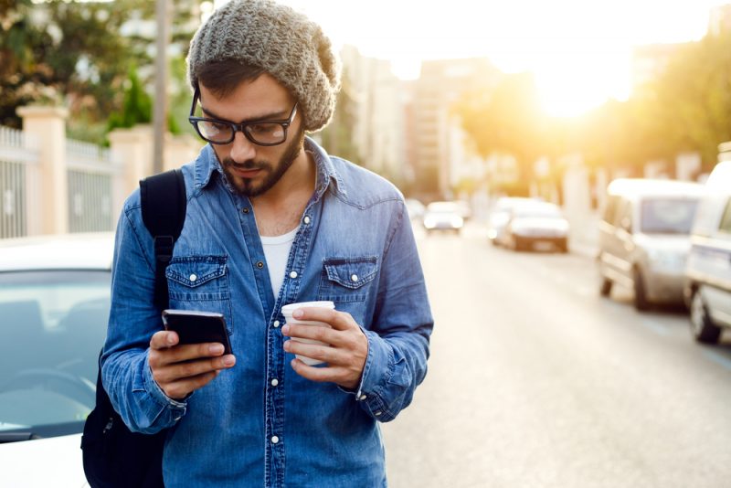 Man Looking at Phone Outside