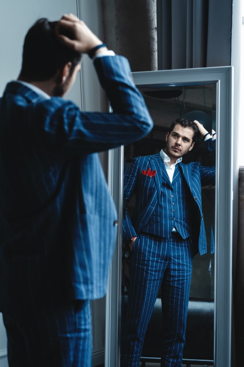 Man in Dapper Three Piece Suit Looking in Mirror