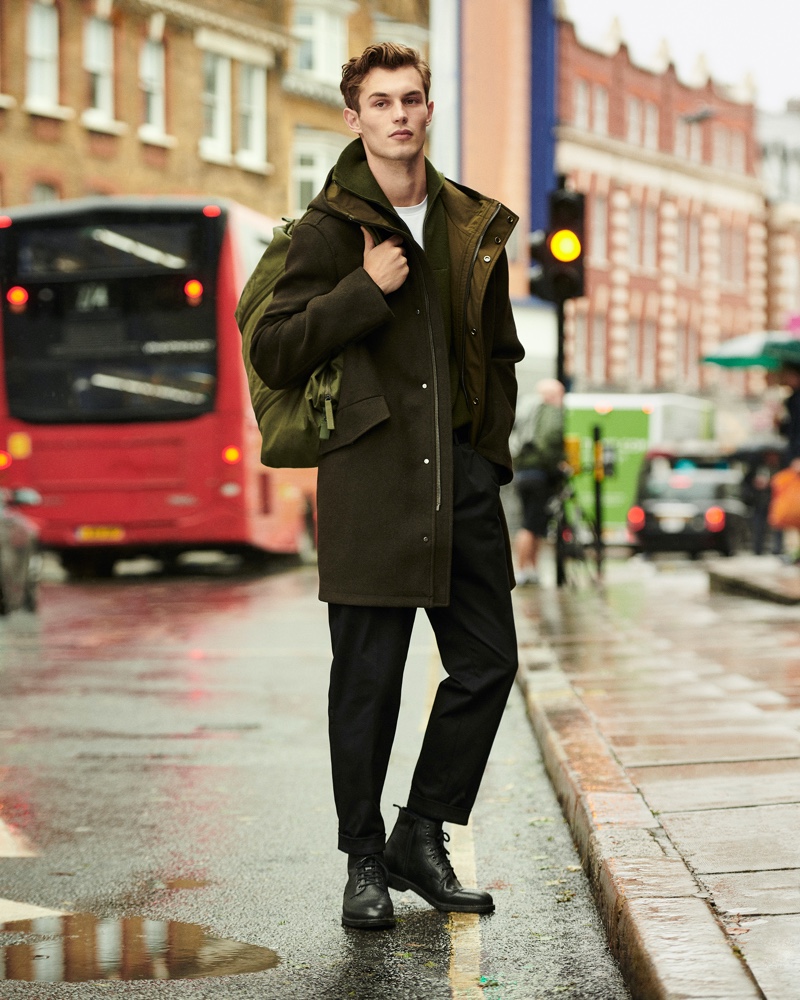 Taking to the wet city streets, Kit Butler makes a case for monochromatic style. Stopping for a photo, Kit wears a parka with a knit sweater, trousers, and leather boots from Mango's Urban Essentials collection.