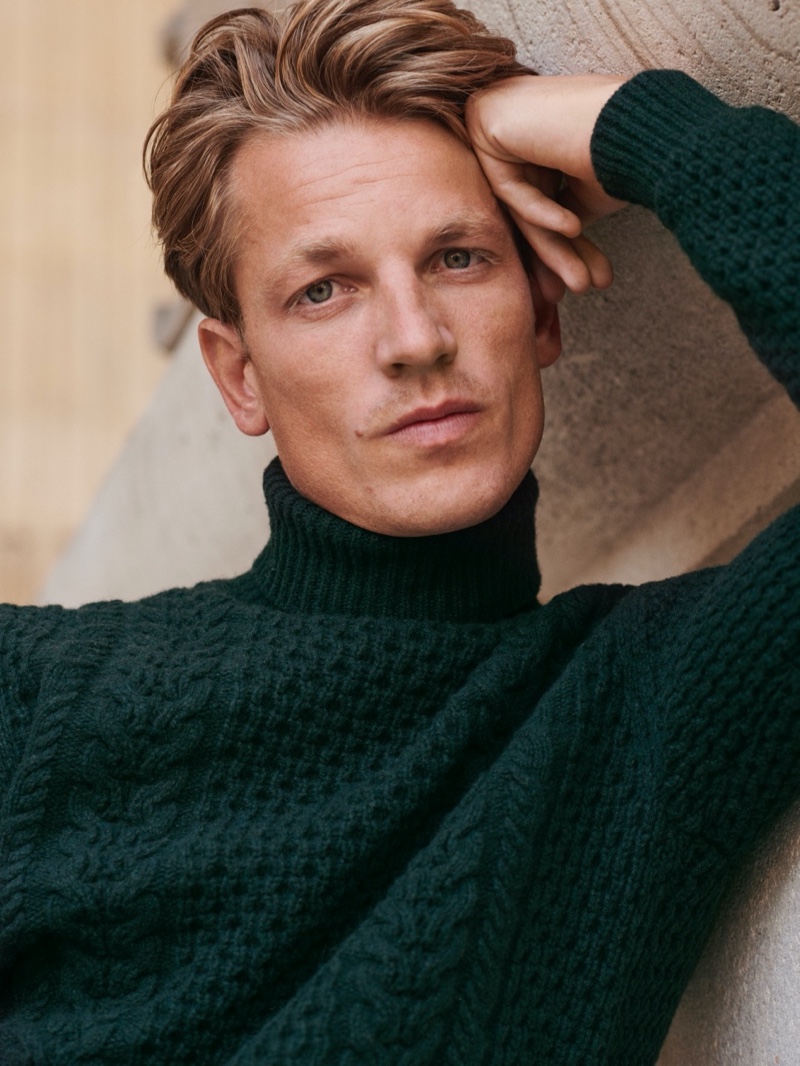 Front and center, Hugo Sauzay models a green cable-knit sweater from Massimo Dutti's fall-winter 2020 collection.