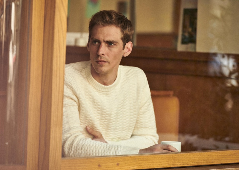 French model Jeremy Dufour steals a moment in a Parisian cafe as he showcases a sweater from Octobre's fall-winter 2020 collection.