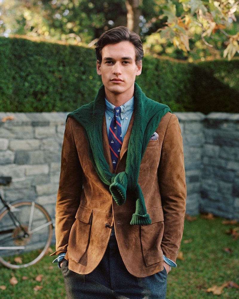 Jegor Venned is a posh vision in fall menswear from POLO Ralph Lauren. The top model dons a brown suede blazer with a POLO denim shirt and cable-knit sweater in green.