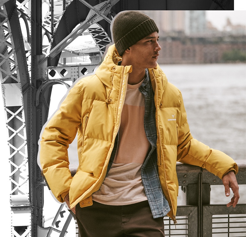 Pictured outdoors, Marco Pickett sports an AER classic down puffer jacket in saffron ripstop from The Arrivals.