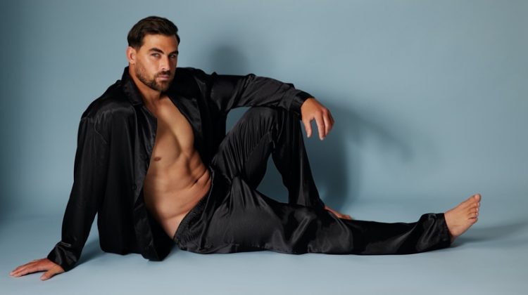 Model Marc Jacobs wears a black satin pajama set from Frederick's of Hollywood.