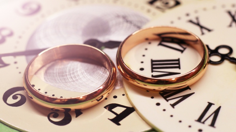 Gold Wedding Rings Against Roman Numerals