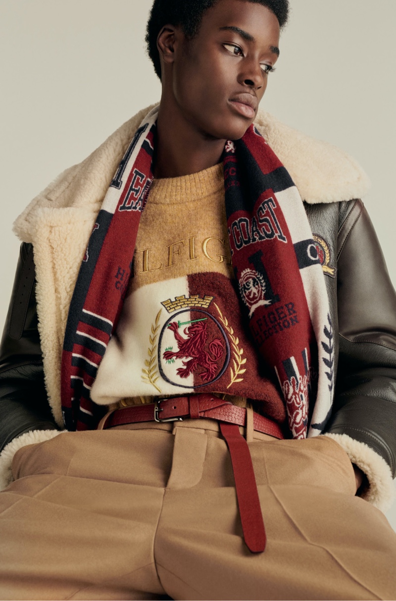 Babacar N'doye wears a shearling aviator jacket with a crest and flag sweater and relaxed pants from Hilfiger Collection.