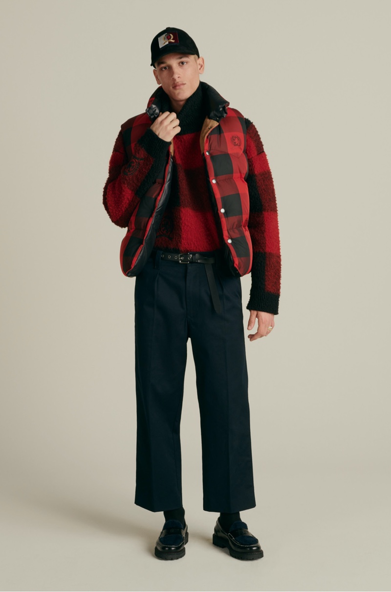 Front and center, Marco Pickett models a Hilfiger Collection suede cap, reversible Re:Down vest, buffalo check turtleneck sweater, relaxed pleated chinos, and skinny rock belt.