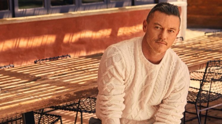 Actor Luke Evans sports a Todd Snyder cable fisherman's sweater in off white with cream and black houndstooth wool pleated pants.