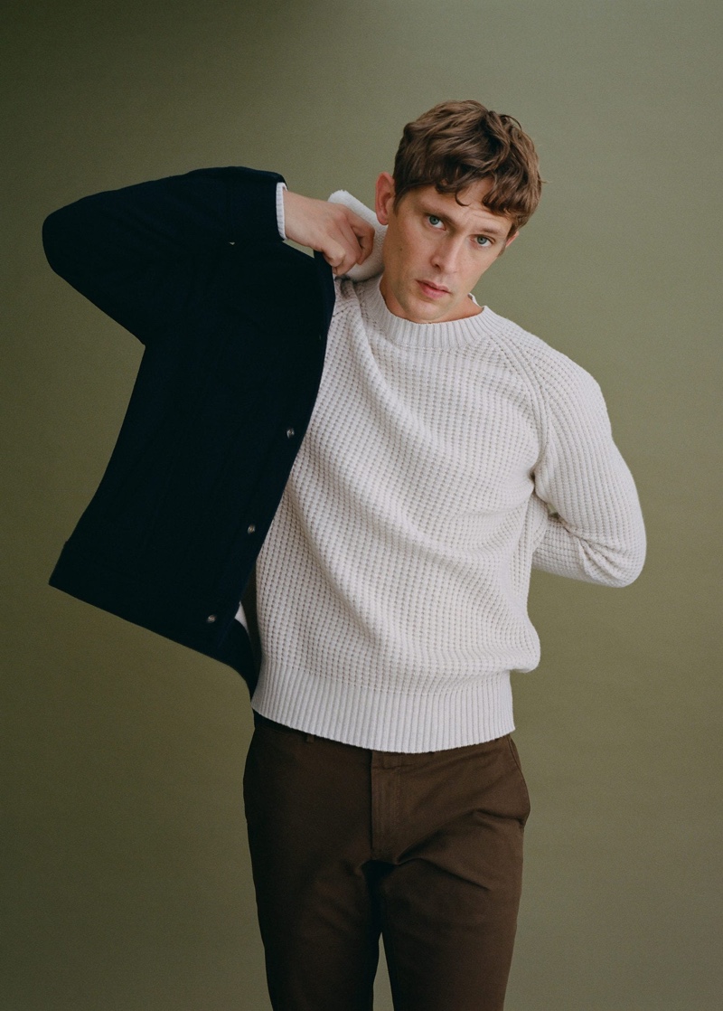 Front and center, Mathias Lauridsen dons a knit sweater, trousers, and a warm jacket from Mango.