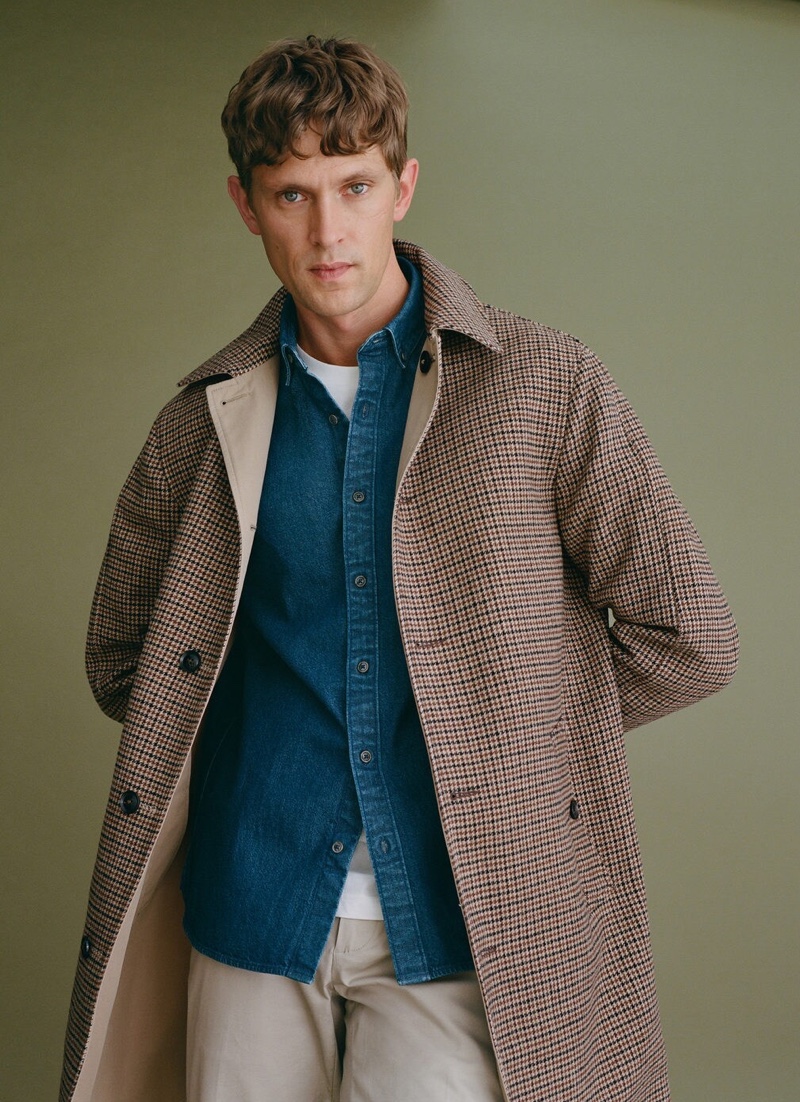 Donning a check coat and denim shirt, Mathias Lauridsen wears Mango.