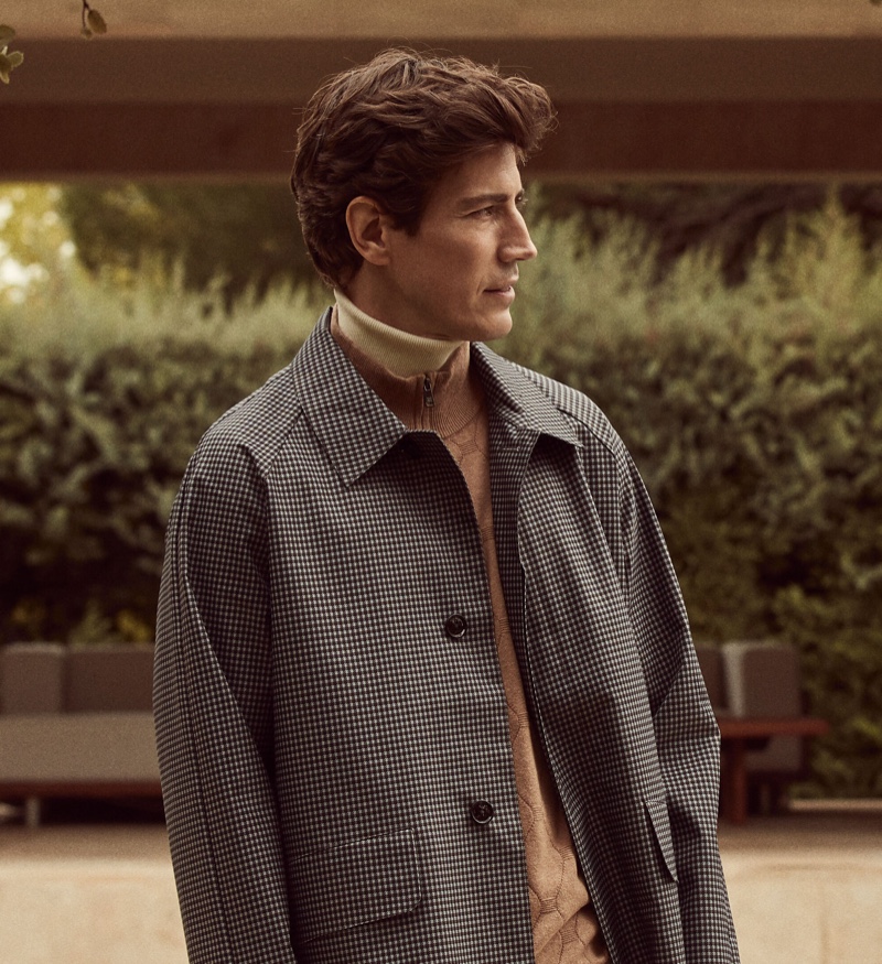 Spanish model Oriol Elcacho wears a houndstooth coat with a layered turtleneck sweater and zippered collar sweater.