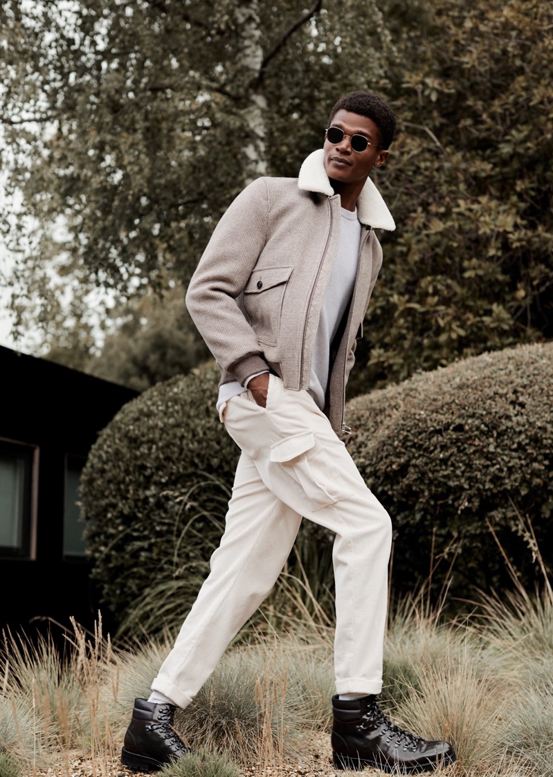 A sleek vision, O'Shea Robertson dons a jacket, sweater, and cargo trousers for Reiss' winter 2020 campaign.