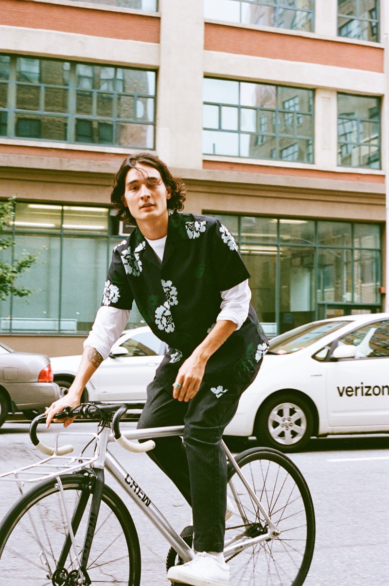 Riding a bike, Sebastião Hungerbühler wears Saturdays New York City's Canty Rose shirt with its Dean trousers.