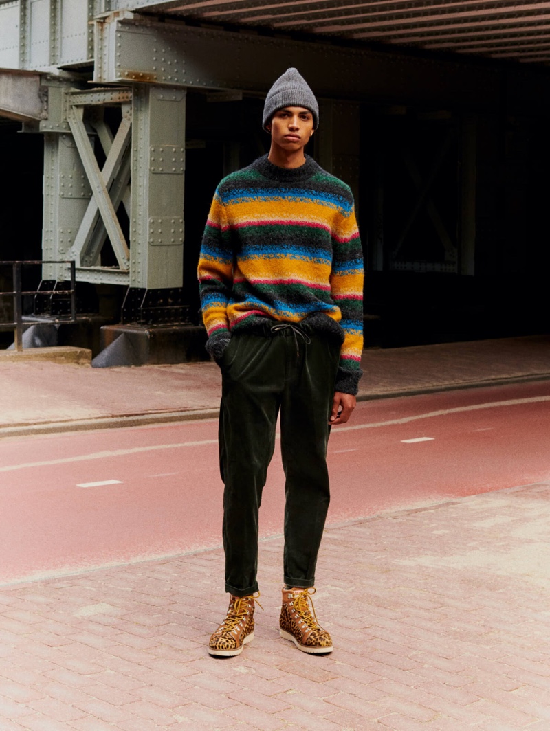 Front and center, Sol Goss models a colorful striped sweater with drawstring pants by Scotch & Soda.