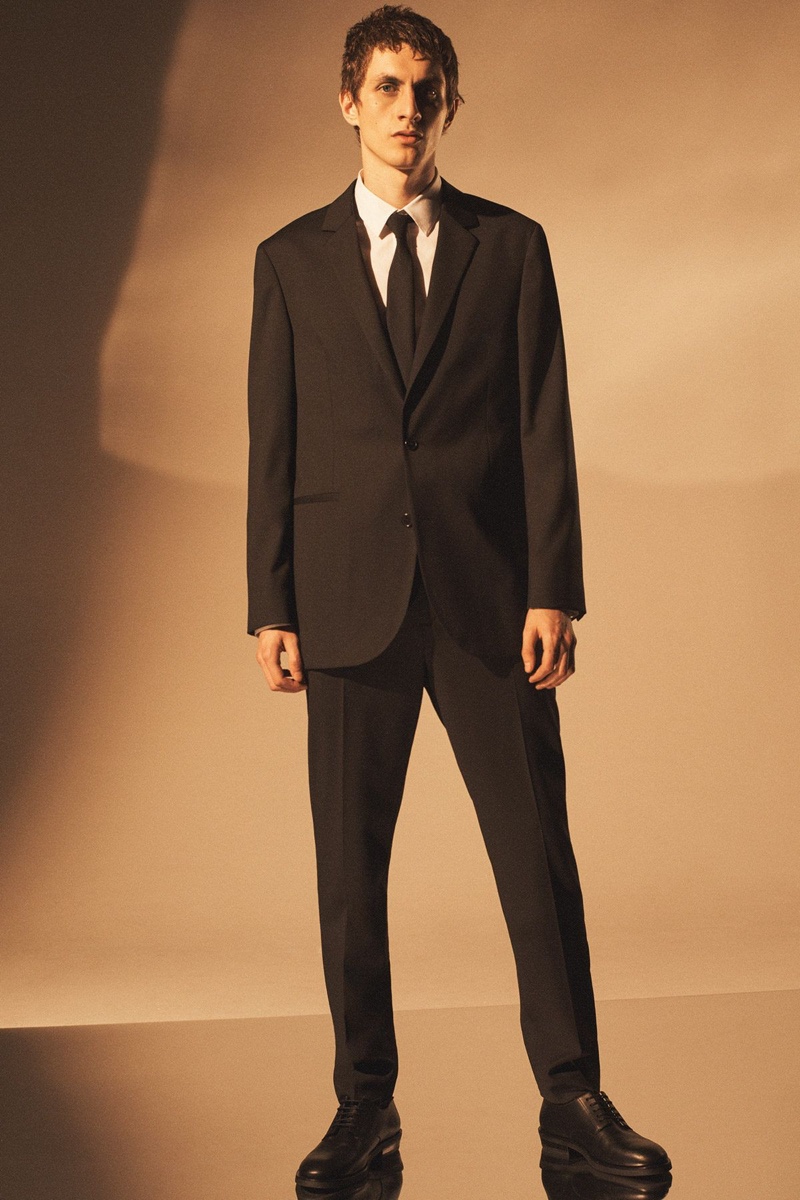 Henry Kitcher dons a sleek suit for COS' holiday 2020 men's campaign.