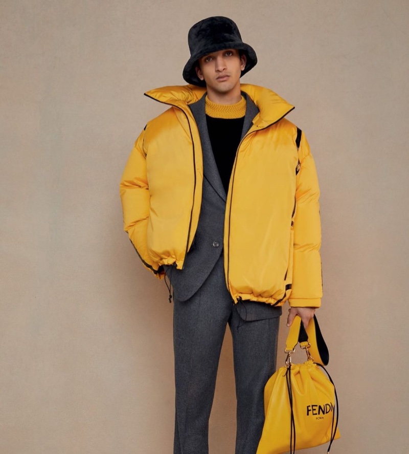 Noah Sapon dons a yellow puffer jacket over a gray suit from Fendi's fall-winter 2020 collection.