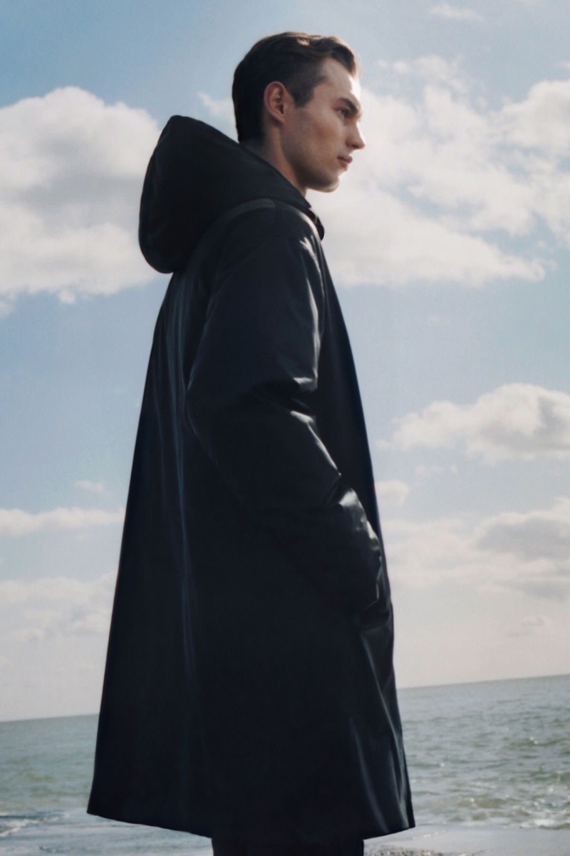 Photographed from his side, Kit Butler wears a recycled polyamide down-lined waterproof coat from COS.