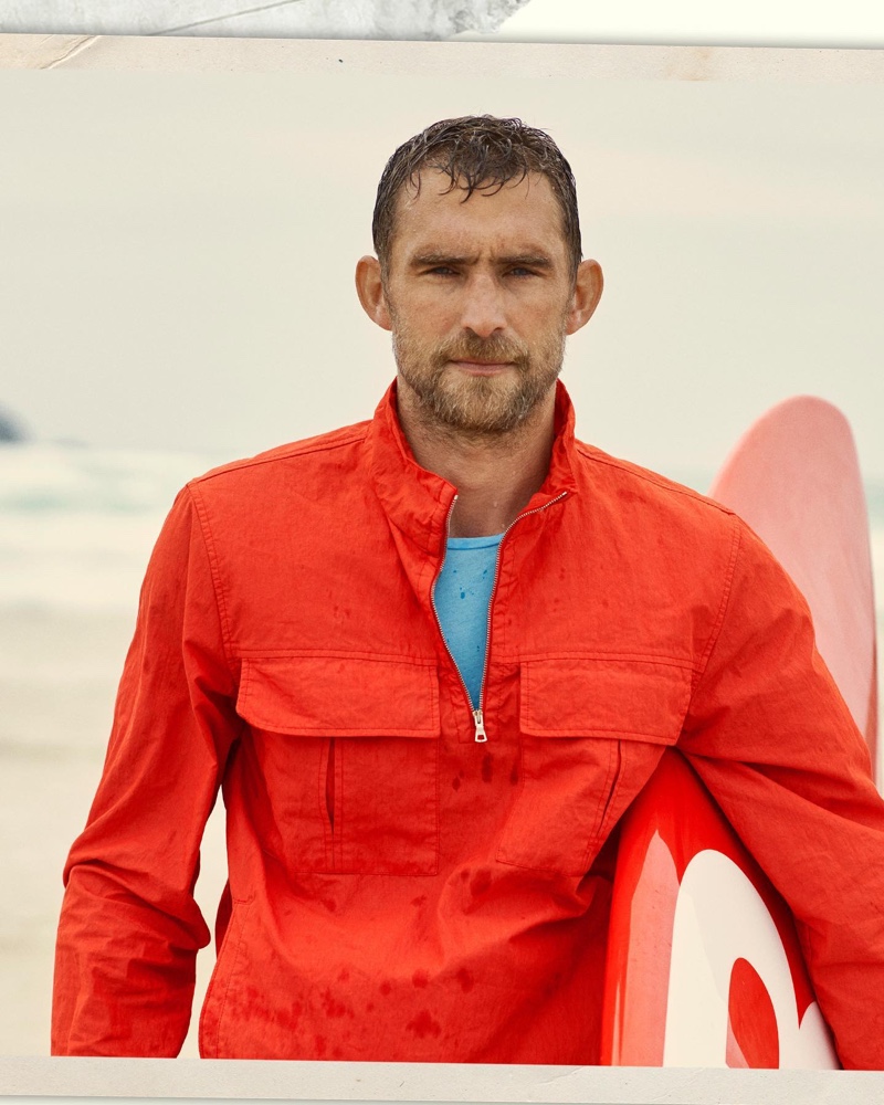 British model Will Chalker dons a rescue red smock jacket by Orlebar Brown.