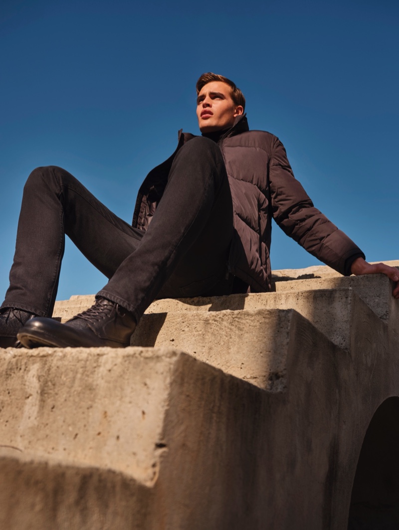 Sporting a quilted jacket and black denim jeans, Parker van Noord models Massimo Dutti.