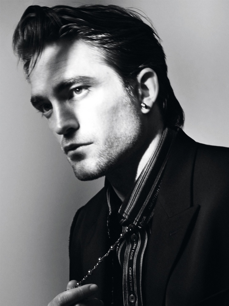 Delivering a side profile, Robert Pattinson appears in a black and white photograph for Dior magazine.