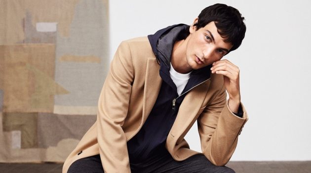Luca, Roch & Shawn Don the New Casual for BOSS Sitting for a portrait, Luca Lemaire wears a BOSS camel coat with full-zip hooded jacket and pants.