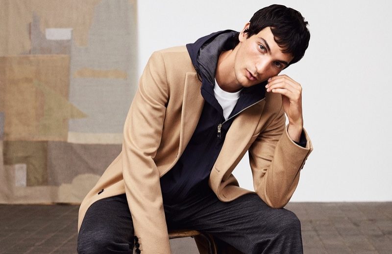Luca, Roch & Shawn Don the New Casual for BOSS Sitting for a portrait, Luca Lemaire wears a BOSS camel coat with full-zip hooded jacket and pants.