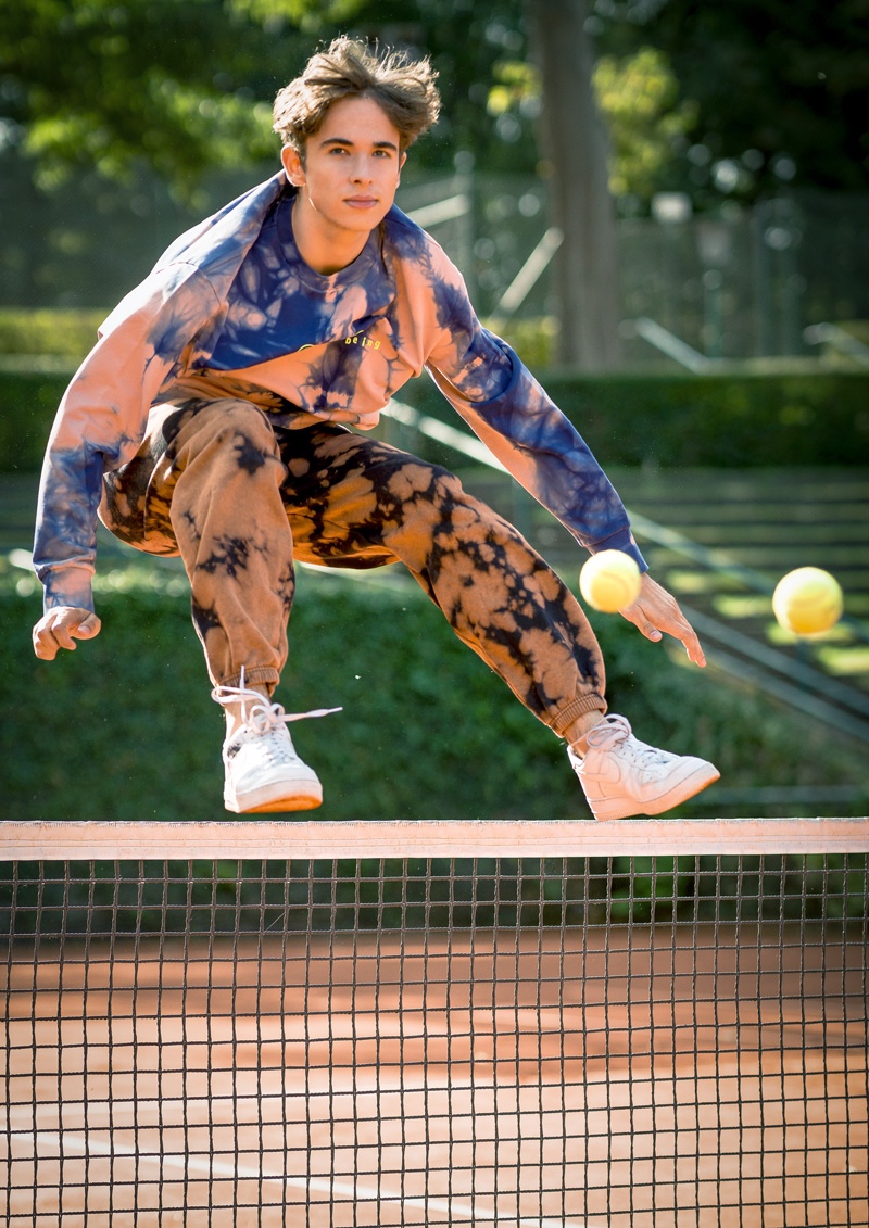 Luis wears tie-dye sweatshirt Diesel, pants iets frans, and sneakers Nike.