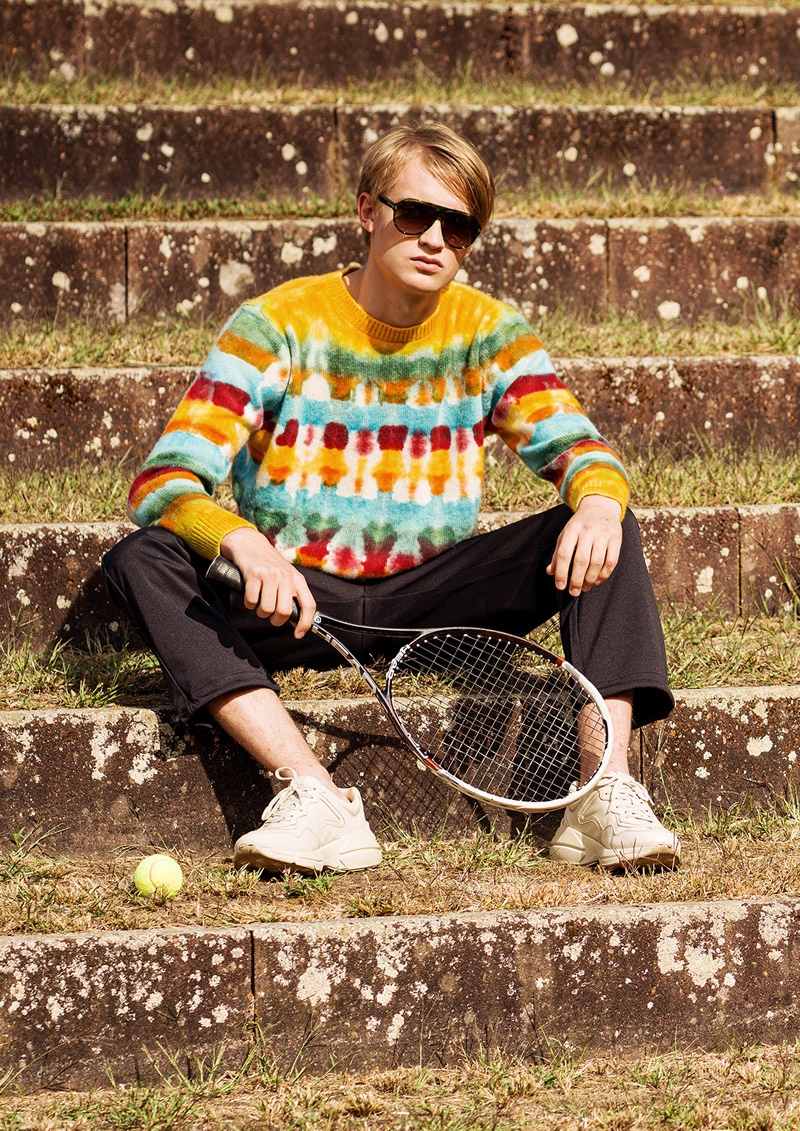 Fynn wears sweater The Elder Statesman, pants Fred Perry, and sneakers Gucci.