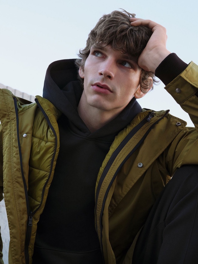 Front and center, Erik Van Gils dons a 2-in-1 waterproof jacket with an organic cotton hoodie from Reserved's Premium Sustainable collection.