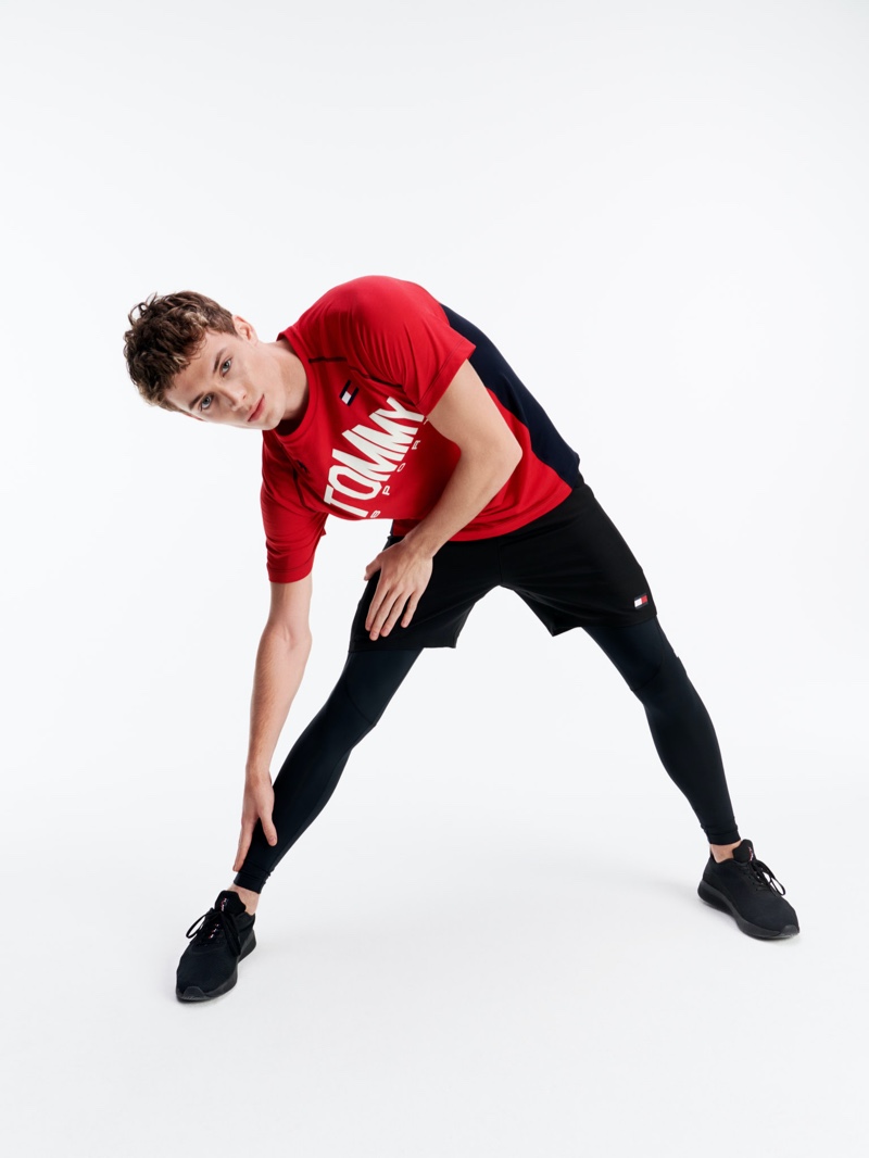 Stretching, João Knorr wears activewear from Tommy Sport.