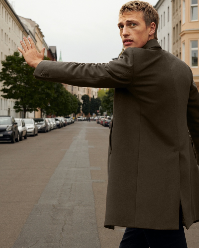 Hailing a taxi, Victor Nylander dons a sharp coat from Massimo Dutti.