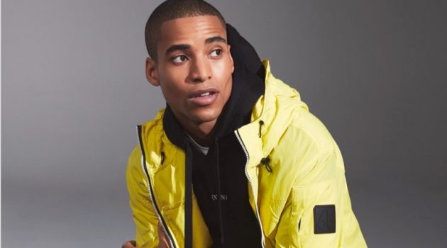 Malik Dons Transitional Outerwear for Holt Renfrew Front and center, Malik Lindo wears a yellow windbreaker by Moose Knuckles.