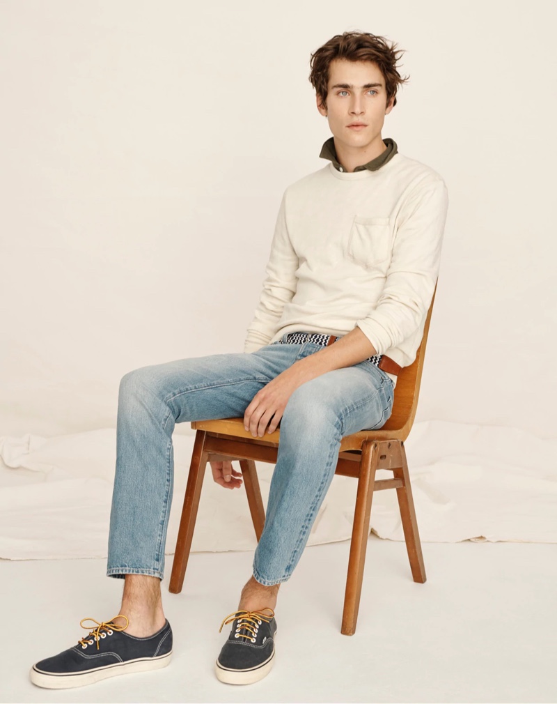 Liam Kelly models a lightweight sun-faded french terry sweatshirt with light wash denim jeans by J.Crew.