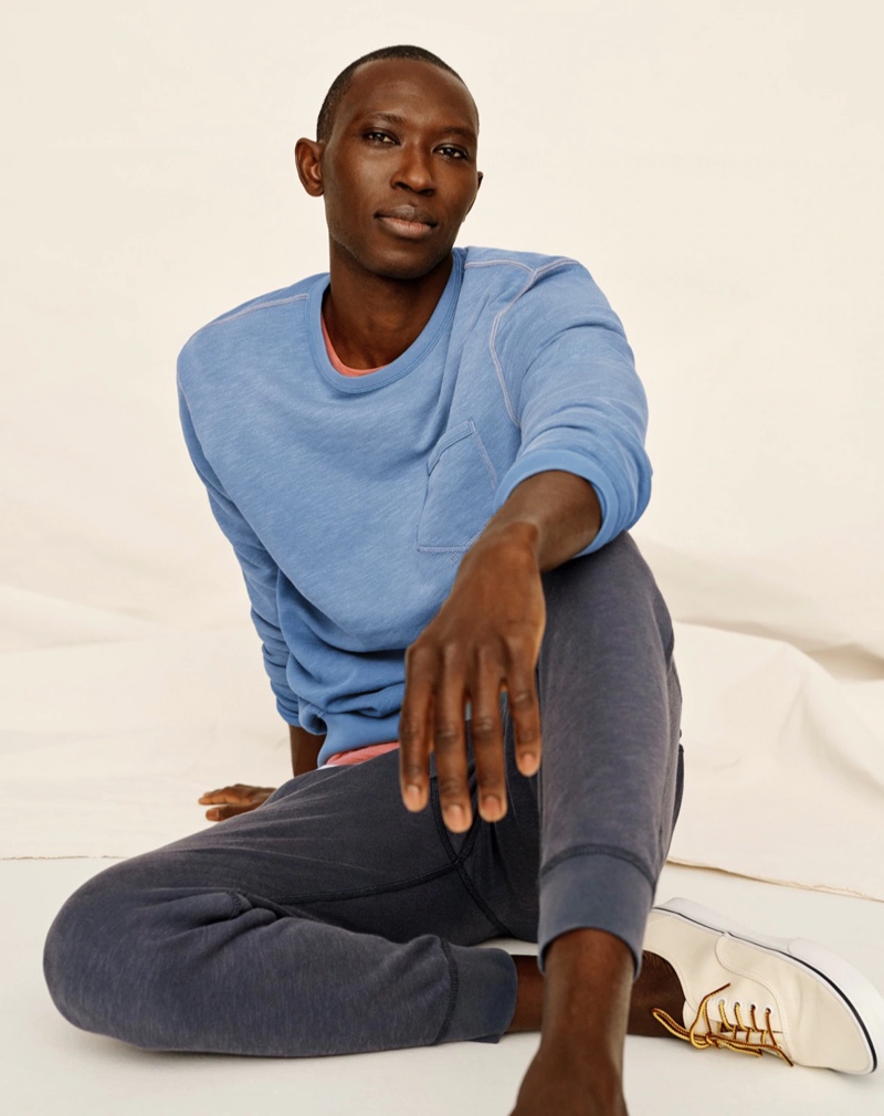 Relaxing, Armando Cabral sports a lightweight sun-faded french terry sweatshirt and jogger sweatpants from J.Crew.