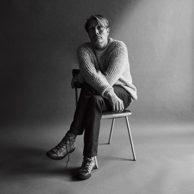 Mads Mikkelsen dons an Isabel Marant sweater with a Nanushka t-shirt, and A.P.C. jeans for WSJ Magazine.