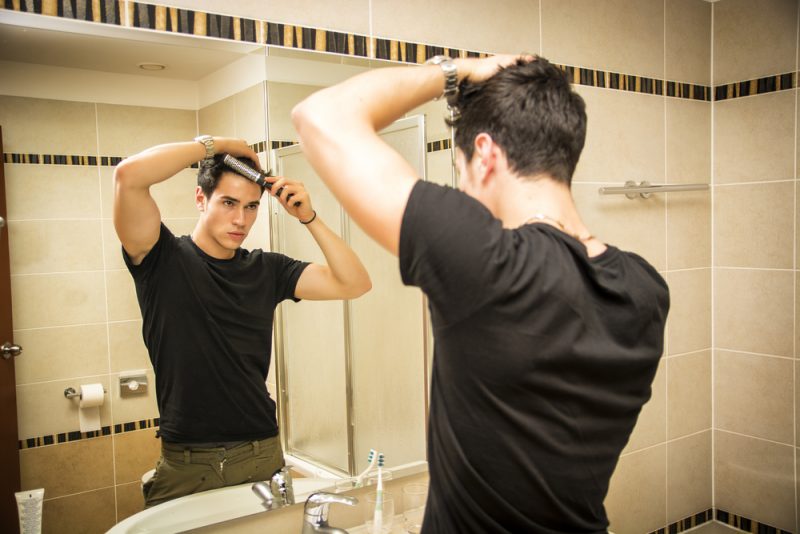 Man Brushing Hair in Mirror