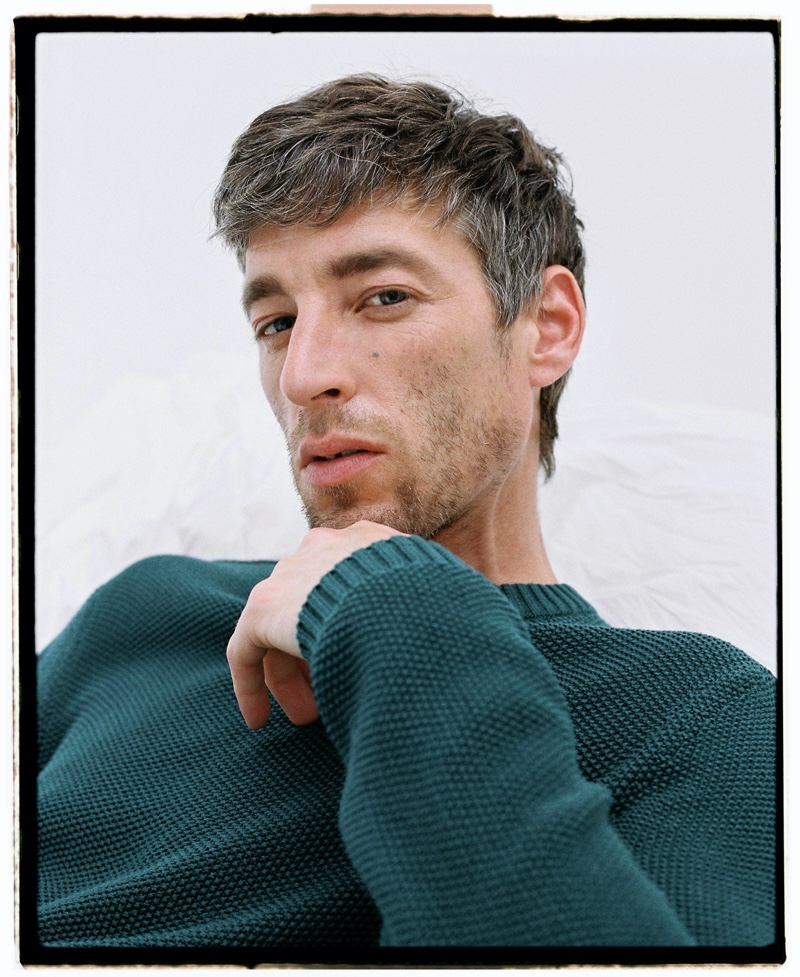 Relaxing, Joel Frampton sports a textured sweater from Adolfo Dominguez's spring-summer 2021 men's collection.