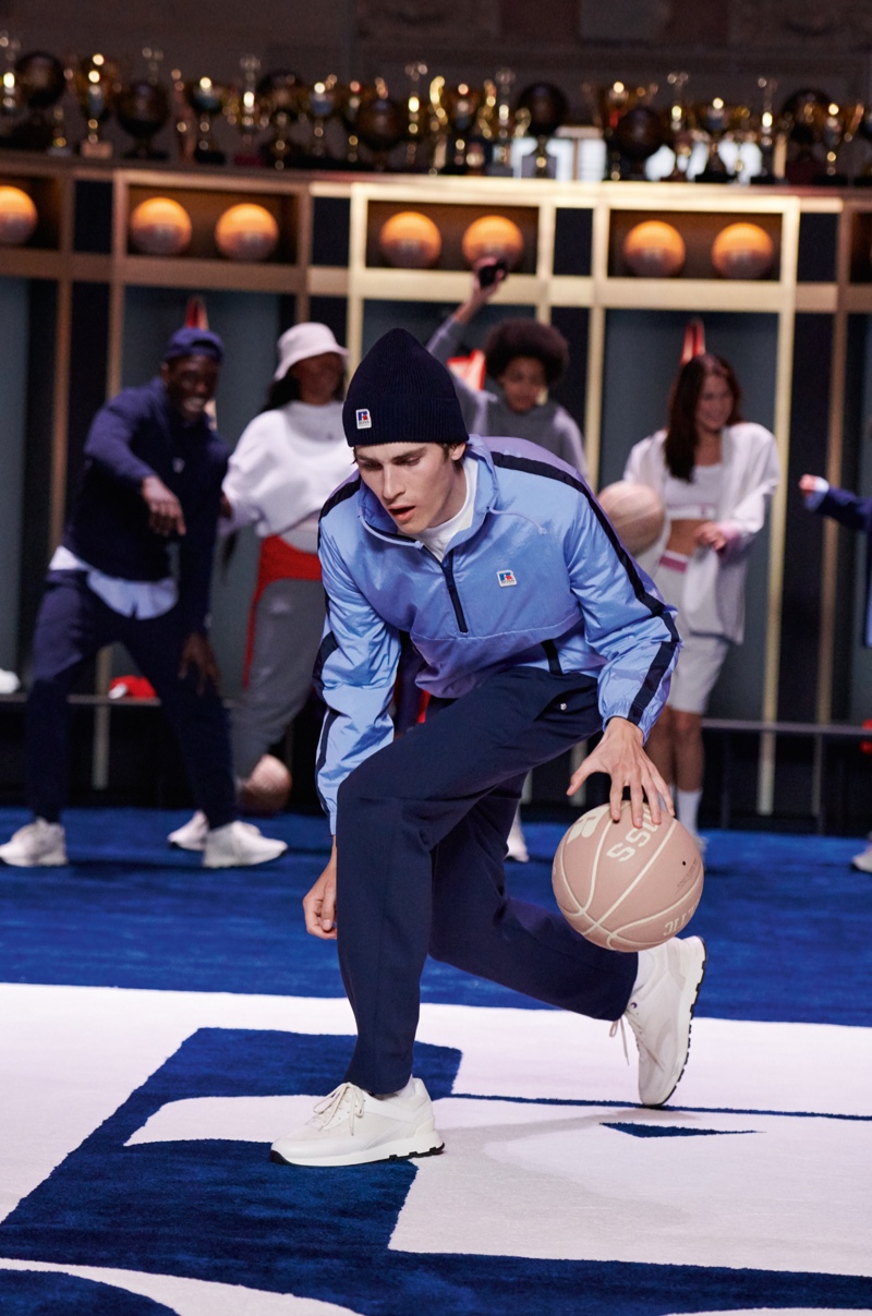 Dribbling a basketball, Liam Kelly wears a look from the BOSS x Russell Athletic collection.