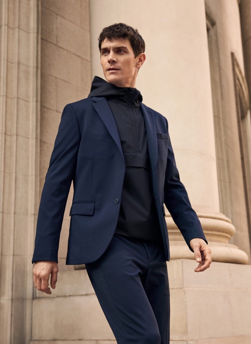 Embracing a navy and black look from Mango's High-Performance collection, Vincent Lacrocq wears a combined knitted sweatshirt with a suit.