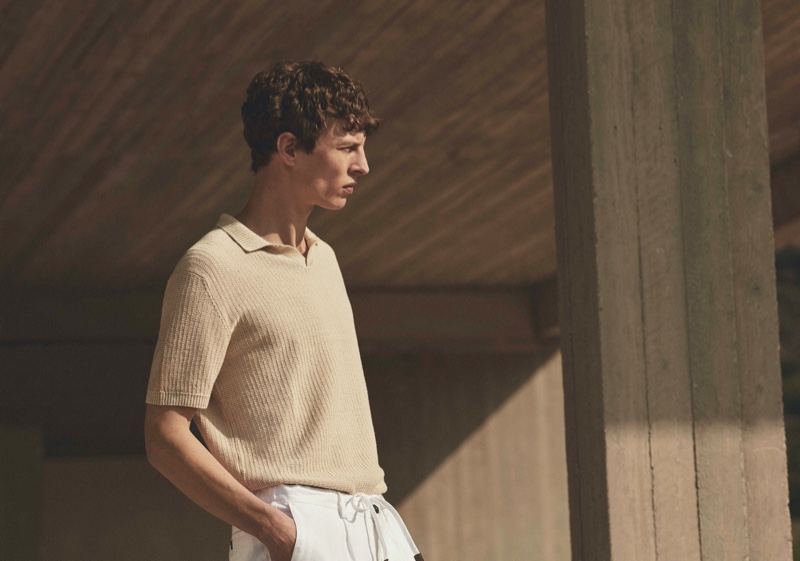 Delivering a side profile, Tim Schuhmacher inspires in a sleek v-neck polo sweater from Massimo Dutti's spring 2021 Limited Edition collection.