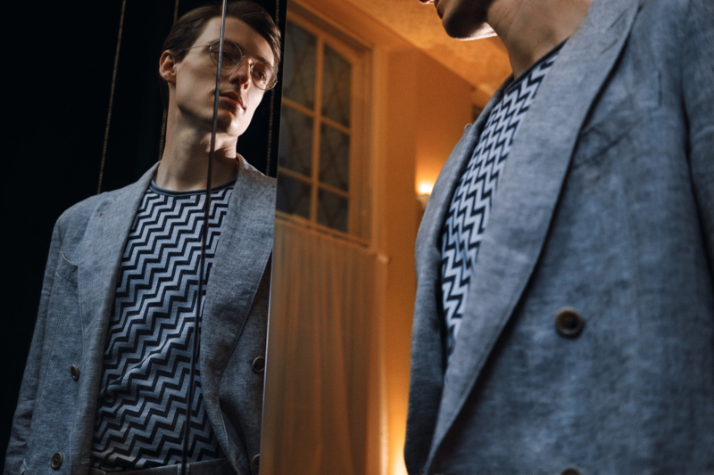 Posing in front of a mirror, Tommaso de Benedictis wears a Giorgio Armani double-breasted mélange linen suit jacket and Intarsia silk, cashmere, and linen-blend sweater from Mr Porter.