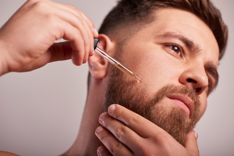 Man Applying Beard Growth Oil Man Applying Beard Growth Oil