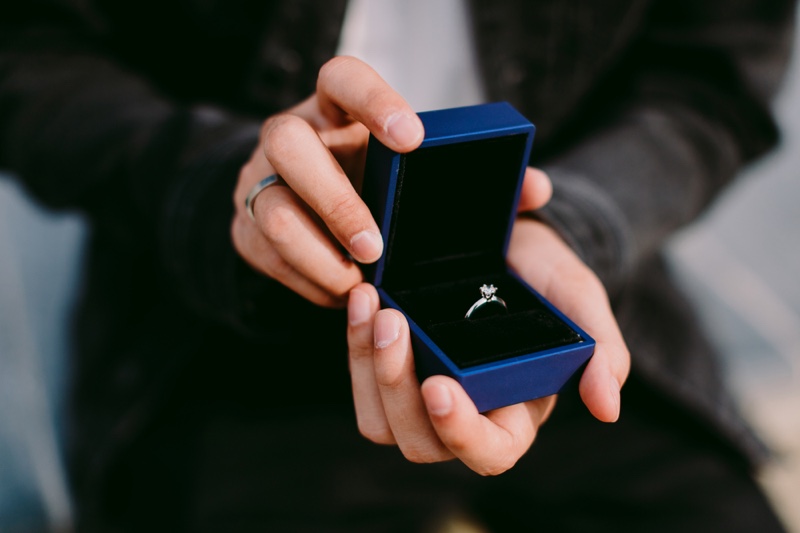 Man Holding Blue Engagement Ring Box