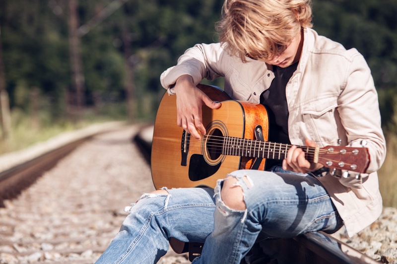Man Playing Guitar Train Tracks Ripped Jeans White Jacket Man Playing Guitar Train Tracks Ripped Jeans White Jacket