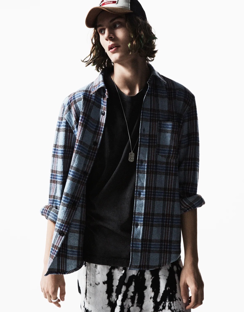 Front and center, Zachary Norton wears a Zara plaid shirt with bleached pants.